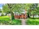 Charming brick home with inviting front porch and mature trees providing ample shade at 1523 E Mills Ave, Indianapolis, IN 46227