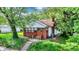 Charming single-story home featuring brick accents, a cozy front porch, and mature trees in a lush green lawn at 1523 E Mills Ave, Indianapolis, IN 46227