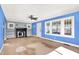 Spacious living room with bright blue walls, vintage fireplace, and large windows that flood the room with natural light at 1523 E Mills Ave, Indianapolis, IN 46227