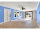 Bright living room featuring large windows, a ceiling fan, and a sliding glass door, creating a welcoming atmosphere at 1523 E Mills Ave, Indianapolis, IN 46227