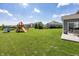 Backyard view featuring a playground, expansive lawn, and residential community at 16419 Connolly Dr, Westfield, IN 46074