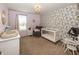 Comfortable Bedroom featuring a white crib, accent wall, and neutral-toned glider at 16419 Connolly Dr, Westfield, IN 46074
