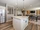 Kitchen island with seating and modern pendant lights, open to the living room and dining area at 16419 Connolly Dr, Westfield, IN 46074