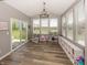 Bright sunroom featuring wood floors, large windows, and built-in shelving for ample storage and backyard views at 16419 Connolly Dr, Westfield, IN 46074