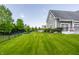 Expansive green backyard enclosed by a black fence with lush landscaping at 1799 Hourglass Dr, Carmel, IN 46032