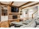 Inviting basement with a brick fireplace, wooden beams, built-in shelving, and comfortable seating at 1799 Hourglass Dr, Carmel, IN 46032