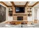 Cozy basement features a brick fireplace flanked by shelving and complemented by rustic wooden beams at 1799 Hourglass Dr, Carmel, IN 46032