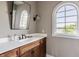 Elegant bathroom features a wood vanity, arched window, and stylish mirror for a luxurious feel at 1799 Hourglass Dr, Carmel, IN 46032