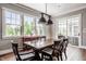 Sunlit dining room features a wooden table and a large windows overlooking a landscaped yard at 1799 Hourglass Dr, Carmel, IN 46032