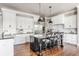 Spacious kitchen with white cabinets, a dark island with bar stool seating, and stainless steel appliances at 1799 Hourglass Dr, Carmel, IN 46032