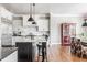 Modern kitchen with white cabinets, granite countertops, and stainless steel appliances adjacent to a dining area at 1799 Hourglass Dr, Carmel, IN 46032