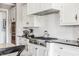 Modern white kitchen with stainless steel range, white subway tile, and black countertop at 1799 Hourglass Dr, Carmel, IN 46032