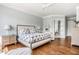 Serene bedroom with hardwood floors, soft blue walls, ceiling fan, and a door leading to what appears to be an additional room at 1799 Hourglass Dr, Carmel, IN 46032