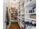 Walk-in pantry features custom shelves, hardwood floors, and ample storage at 1799 Hourglass Dr, Carmel, IN 46032