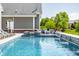 Lush backyard featuring a swimming pool with waterfalls, a hot tub, and outdoor seating at 1799 Hourglass Dr, Carmel, IN 46032