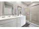 Bathroom with double sinks, framed mirrors, and a glass-enclosed shower at 1807 Orchard Dr, Fortville, IN 46040
