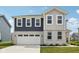 Beautiful two-story home featuring a two-car garage, brick accents, and eye-catching blue and gray siding at 1807 Orchard Dr, Fortville, IN 46040