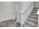 Bright foyer showcasing the front door, staircase with carpet, and wood-look flooring at 1943 Black Oak Dr, Shelbyville, IN 46176
