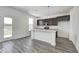 Modern kitchen features dark cabinets, stainless appliances, a marble countertop island, and wood-look flooring at 1943 Black Oak Dr, Shelbyville, IN 46176