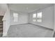 Spacious living room featuring neutral carpet, bright white walls, and large windows with natural light at 1943 Black Oak Dr, Shelbyville, IN 46176
