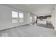 Bright living room with carpet flooring, large windows, and a view of the open kitchen and backyard at 1943 Black Oak Dr, Shelbyville, IN 46176