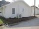 Exterior of home featuring clean white siding, trimmed bushes, and an efficient air conditioning unit at 201 W Essex St, Lebanon, IN 46052