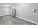 Basement showcasing a water heater, gray walls, a door to outside, and gray vinyl flooring at 2030 Houston St, Indianapolis, IN 46218