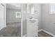 Bathroom boasts grey walls, a sink with a mirror and lighting, and grey carpeted floor in adjoining room at 2030 Houston St, Indianapolis, IN 46218