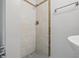 Bathroom showcasing tiled shower with tile trim and shower head, with sink in corner of frame at 2030 Houston St, Indianapolis, IN 46218