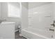 Bathroom features a tub with white tiling, a window with natural light, and a sink vanity with cabinet at 2030 Houston St, Indianapolis, IN 46218