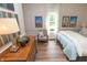 Bright, cheerful bedroom featuring a cozy chair, wood floors, and natural light at 232 S Audubon Rd, Indianapolis, IN 46219