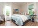 Bright and sunny bedroom with many windows, wood floors, and cozy furnishings at 232 S Audubon Rd, Indianapolis, IN 46219