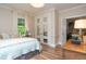 Bright bedroom featuring wood floors and double french doors leading to another room at 232 S Audubon Rd, Indianapolis, IN 46219