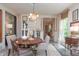 Elegant dining room features a chandelier, stylish furnishings, and natural light from a large window at 232 S Audubon Rd, Indianapolis, IN 46219