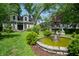 Charming home exterior with a beautiful fountain, lush landscaping, and well-manicured lawn at 232 S Audubon Rd, Indianapolis, IN 46219