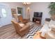 Cozy living room with plush armchairs, a comfortable sofa, and neutral decor at 232 S Audubon Rd, Indianapolis, IN 46219