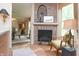 Living room with decorative brick fireplace, light hardwood floors, and an adjacent dining area at 232 S Audubon Rd, Indianapolis, IN 46219