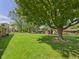 Expansive backyard with lush green grass, mature trees, and a red shed at 25 N Mustin Dr, Anderson, IN 46012