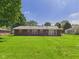Spacious backyard featuring lush green grass and the back of the brick house at 25 N Mustin Dr, Anderson, IN 46012