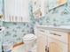 Charming half-bath with ornate blue wallpaper, vanity, and decorative accents at 25 N Mustin Dr, Anderson, IN 46012