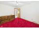 Bedroom with wood dresser, red carpet, a ceiling fan and access to the hallway at 25 N Mustin Dr, Anderson, IN 46012