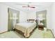 Bedroom with patterned comforter, wood headboard, ceiling fan, and green carpet at 25 N Mustin Dr, Anderson, IN 46012
