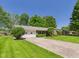 Quaint ranch-style home with attached garage, mature trees, and large front yard at 25 N Mustin Dr, Anderson, IN 46012