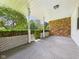 Spacious covered porch with brick wall and white columns, perfect for relaxing at 25 N Mustin Dr, Anderson, IN 46012
