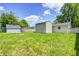 Grassy backyard features multiple storage sheds and wood fencing at 3072 Falcon Dr, Indianapolis, IN 46222