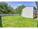Fenced yard features grassy area, storage sheds, and some mature trees at 3072 Falcon Dr, Indianapolis, IN 46222