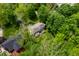 Aerial shot highlighting a home with a backyard deck, set amidst vibrant green trees at 3230 Amherst St, Indianapolis, IN 46268