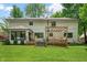 Expansive backyard with a well-maintained lawn, mature trees, and a charming wooden patio at 3230 Amherst St, Indianapolis, IN 46268