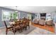 Open concept living and dining areas with hardwood floors, a stone fireplace, and large windows at 3230 Amherst St, Indianapolis, IN 46268