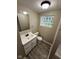 Bathroom with laminate floors, a vanity, and a glass block window at 3628 Breen Dr, Indianapolis, IN 46235